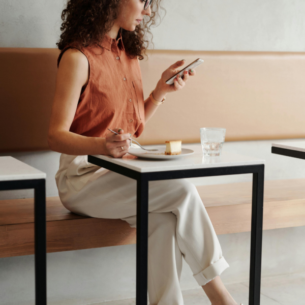 Woman looking at her phone while eating