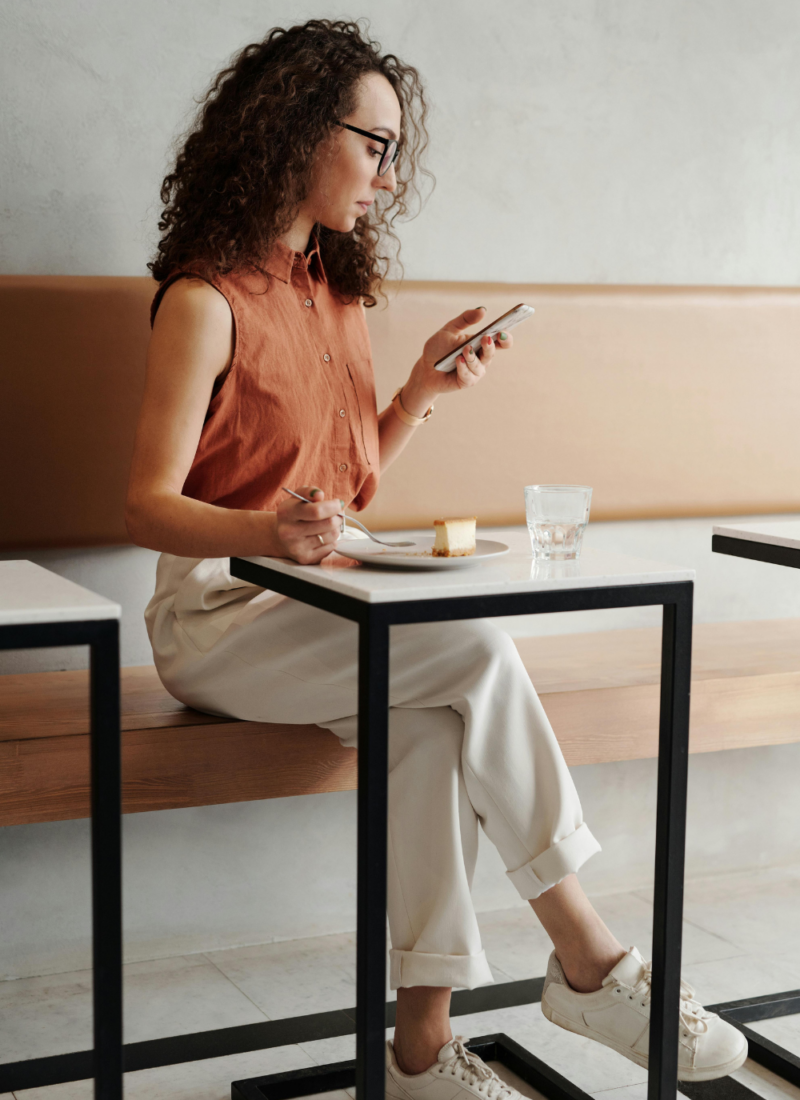 Woman looking at her phone while eating