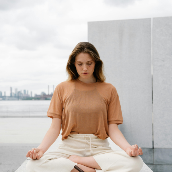 Woman meditating in an open space Her New Habits