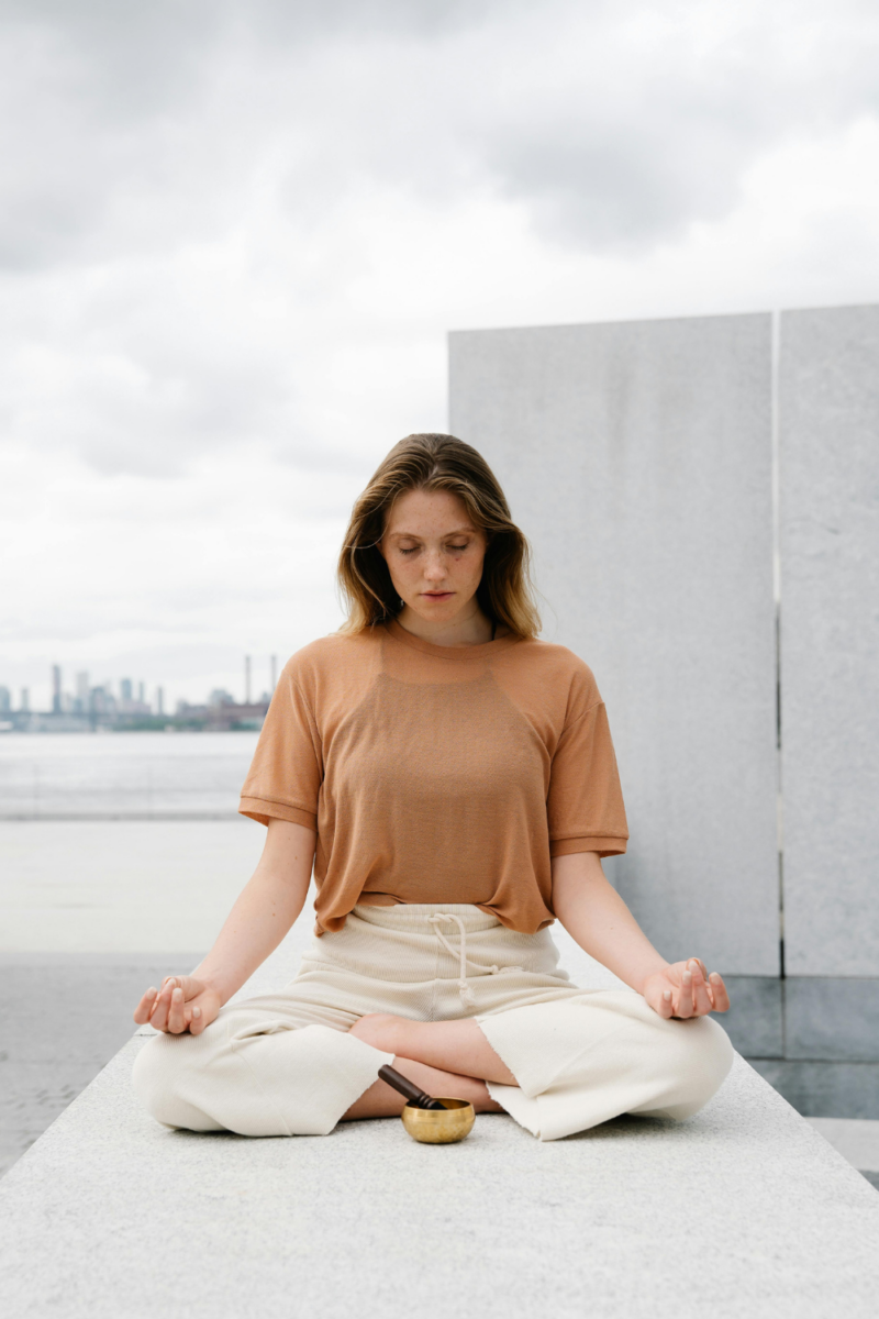 Woman meditating in an open space Her New Habits